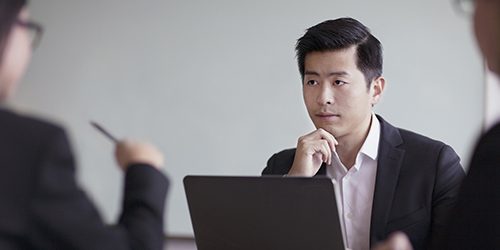 Businessman looking across table in office meeting